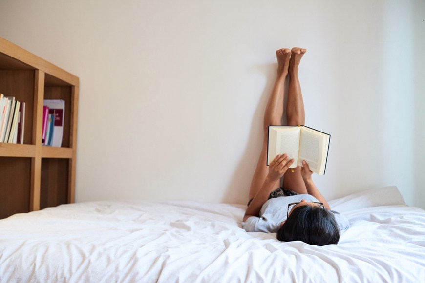 Nằm gác chân lên tường là bài tập tăng chiều cao có thể áp dụng ngay trên giường trước giờ ngủ